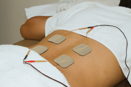 Patient applying electrical stimulation therapy ( TENS ) on his Patient applying electrical stimulation therapy ( TENS ) on his back