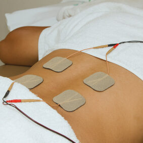 Patient  applying electrical stimulation therapy ( TENS ) on his back